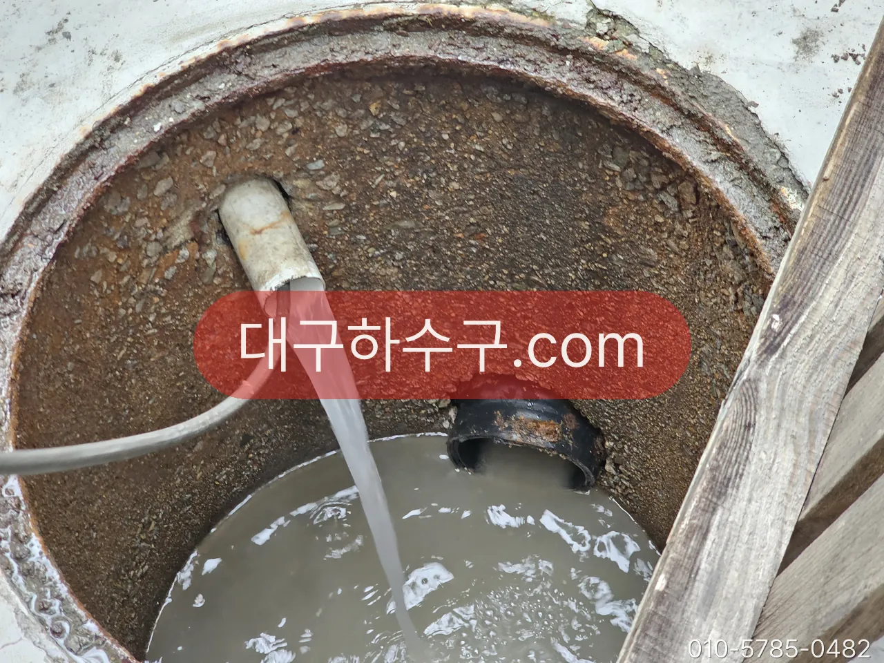 집수정에 고압 호스를 넣어 세척하는 작업